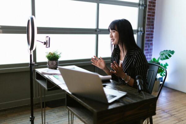 Woman recording a video with a ring light and laptop