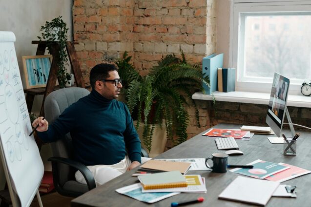 Man pointing to his prepared presentation during an online meeting