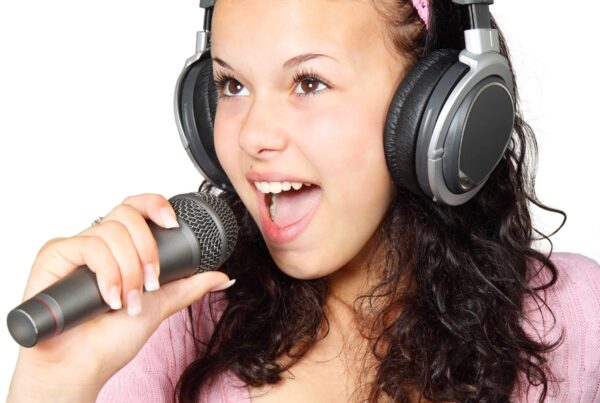 Woman wearing headphones while singing on a microphone