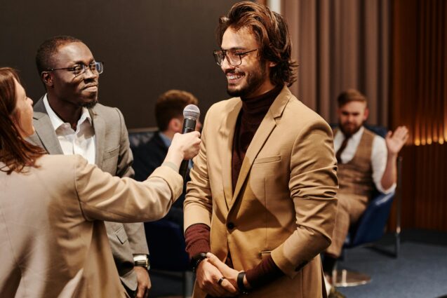 A person giving the microphone to a man