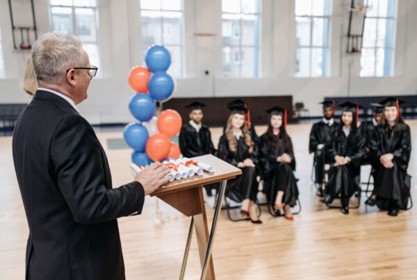 Man speaking at a podium during a graduation ceremony