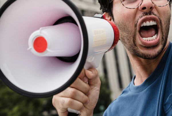 A man with his mouth wide open while holding a megaphone