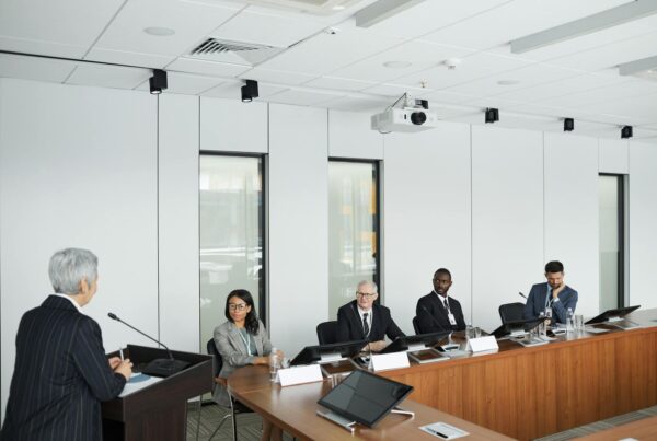 A diverse group of professionals in business attire engaged in discussion around a conference table