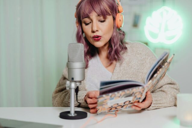 A woman with headphones is deeply focused on a book, illustrating a serene moment of reading