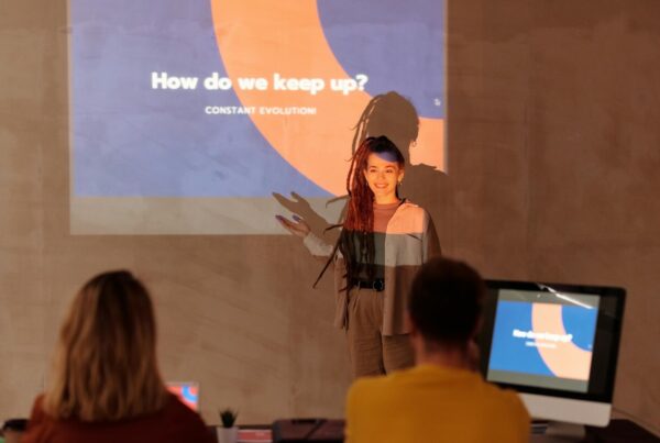 A woman delivers a presentation to an attentive group, showcasing her ideas in a professional setting