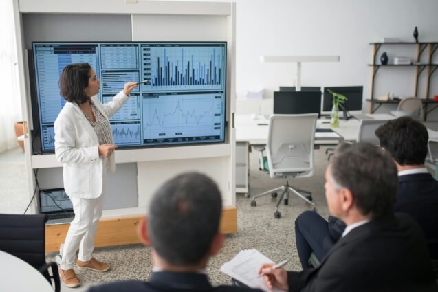 Woman pointing at an infographic projection during a presentation