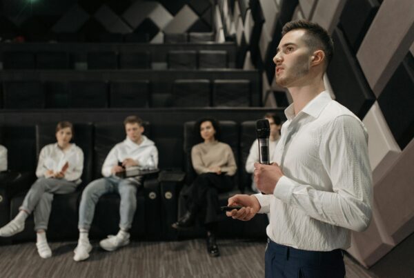 A man wearing white long sleeves speaking