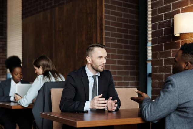 Businessman seated at a table engaged in conversation