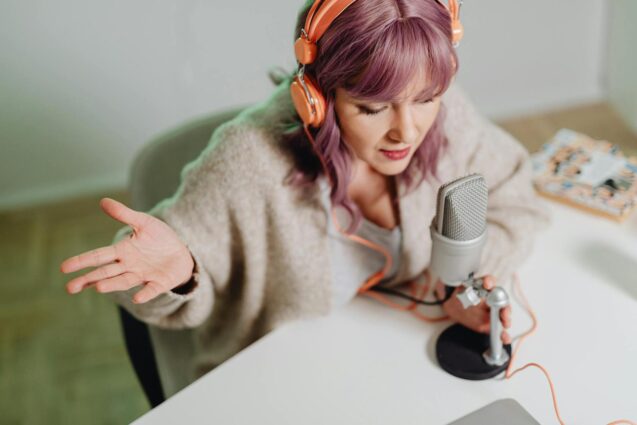 A woman with headphones and speaking into a microphone