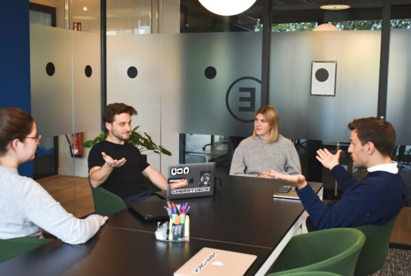 Four people sitting on a table having a discussion