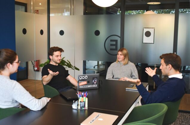 Four people sitting on a table having a discussion