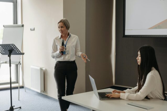 In a conference room, a woman delivers a presentation